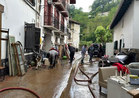 Imagen secundaria 1 - Los vecinos limpian las calle de Bera tras la lluvia torrencial que ha caído esta madrugada. 