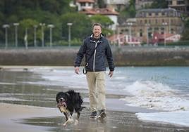 Borja Corominas pasea por la playa de Ondarreta con su perro 'Curu'.
