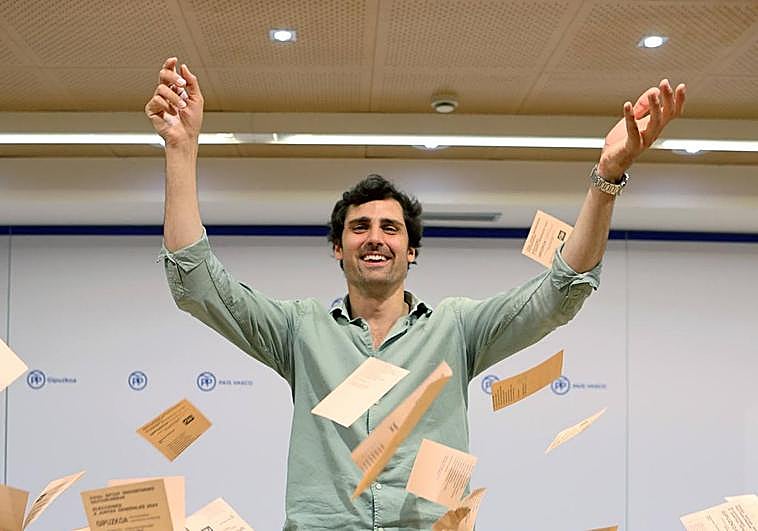 Mikel Lezama lanza al aire decenas de papeletas de voto en la sede que el Partido Popular tiene en Donostia.