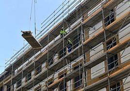 Varios trabajadores colocan los andamios en una obra de rehabilitación.