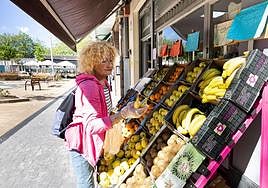 Una pensionista adquiere fruta en un establecimiento.