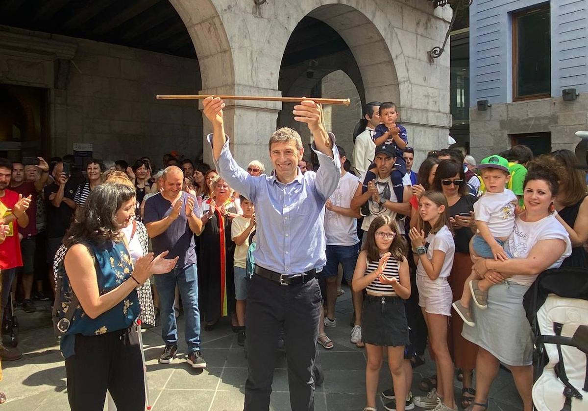 Andu Martínez levanta el bastón de mando en el exterior del Ayuntamiento de Tolosa.