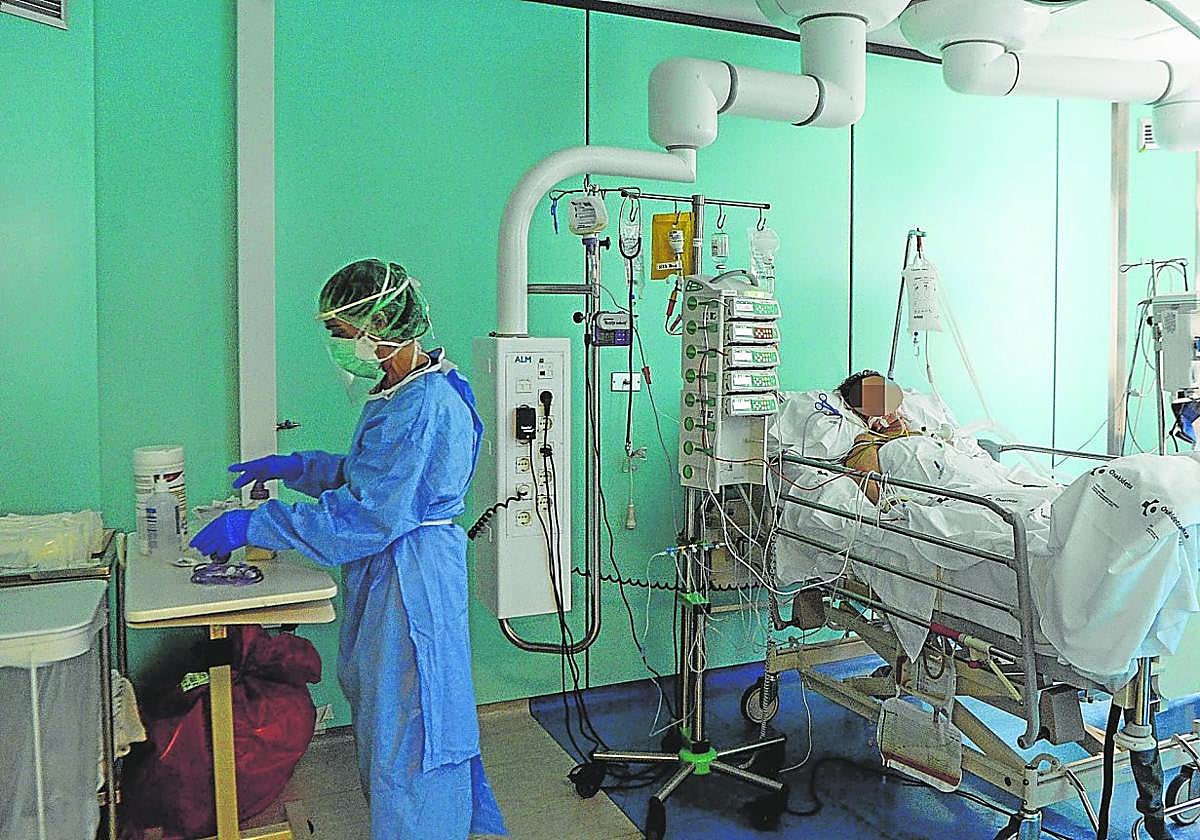 Una sanitaria atiende a un paciente con Covid en una UCI.