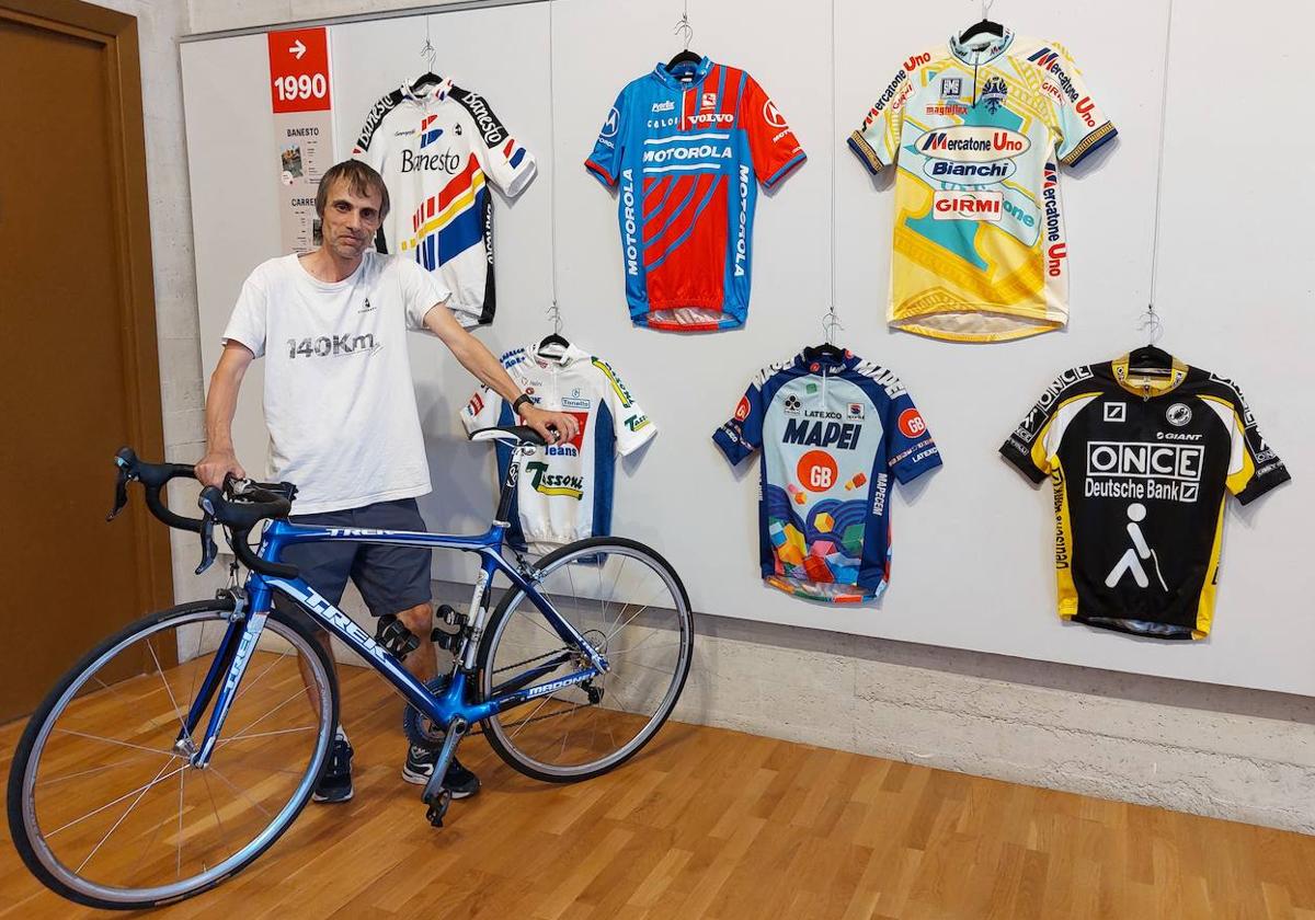 Jon Etxebeste posa junto a algunos de los maillots de la exposición.