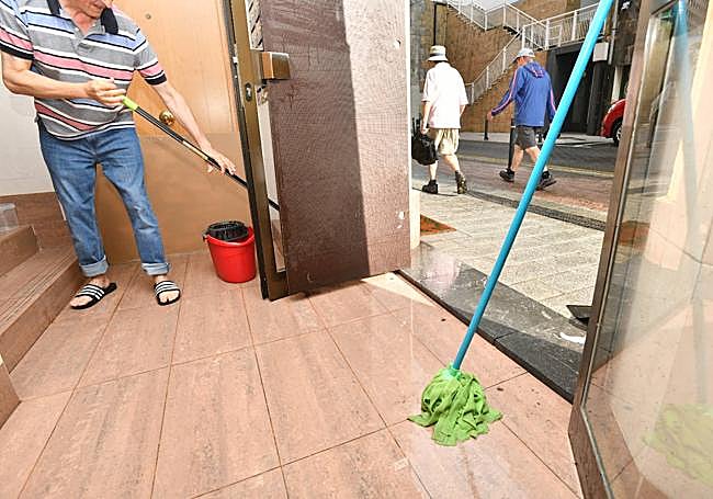 Un hombre achica agua en un portal de Legarre, en Eibar.