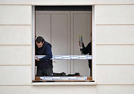 Dos trabajadores colocan un ventanal el un edificio en Eibar.