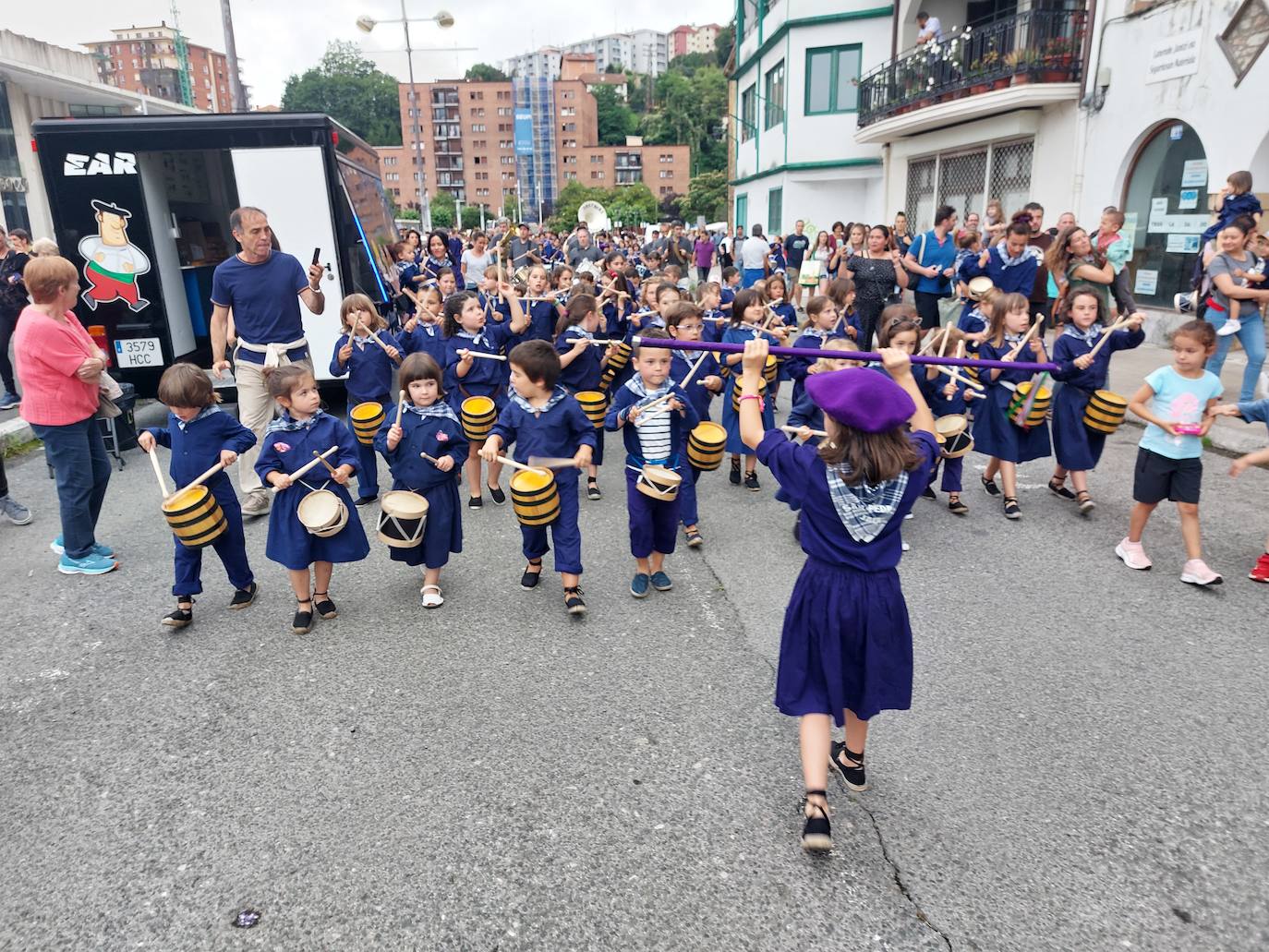 Tamborrada infantil de morado y calles multicolor