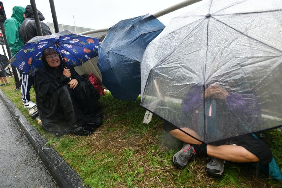 La lluvia no frena a la afición en la zona de meta en Donostia