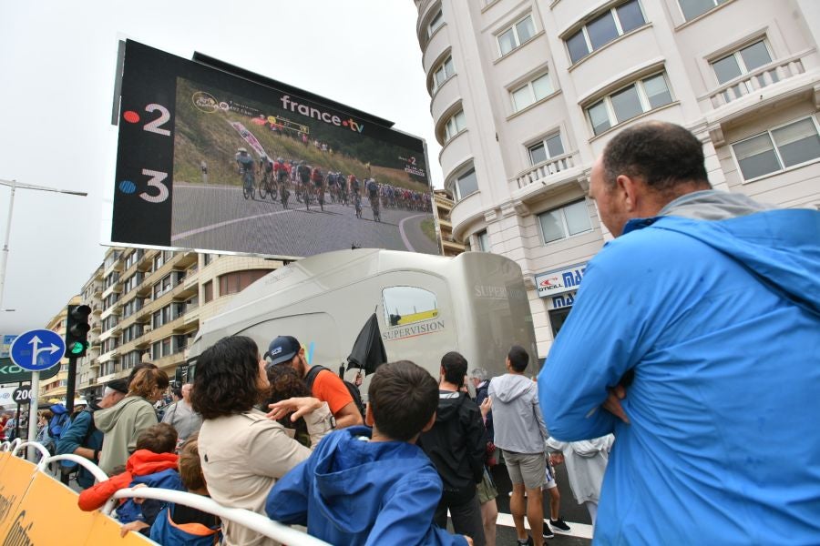 La lluvia no frena a la afición en la zona de meta en Donostia