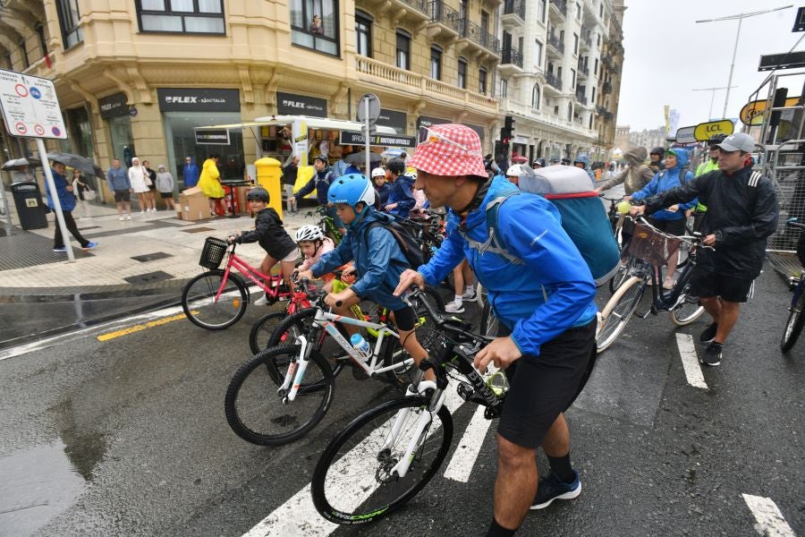 La lluvia no frena a la afición en la zona de meta en Donostia