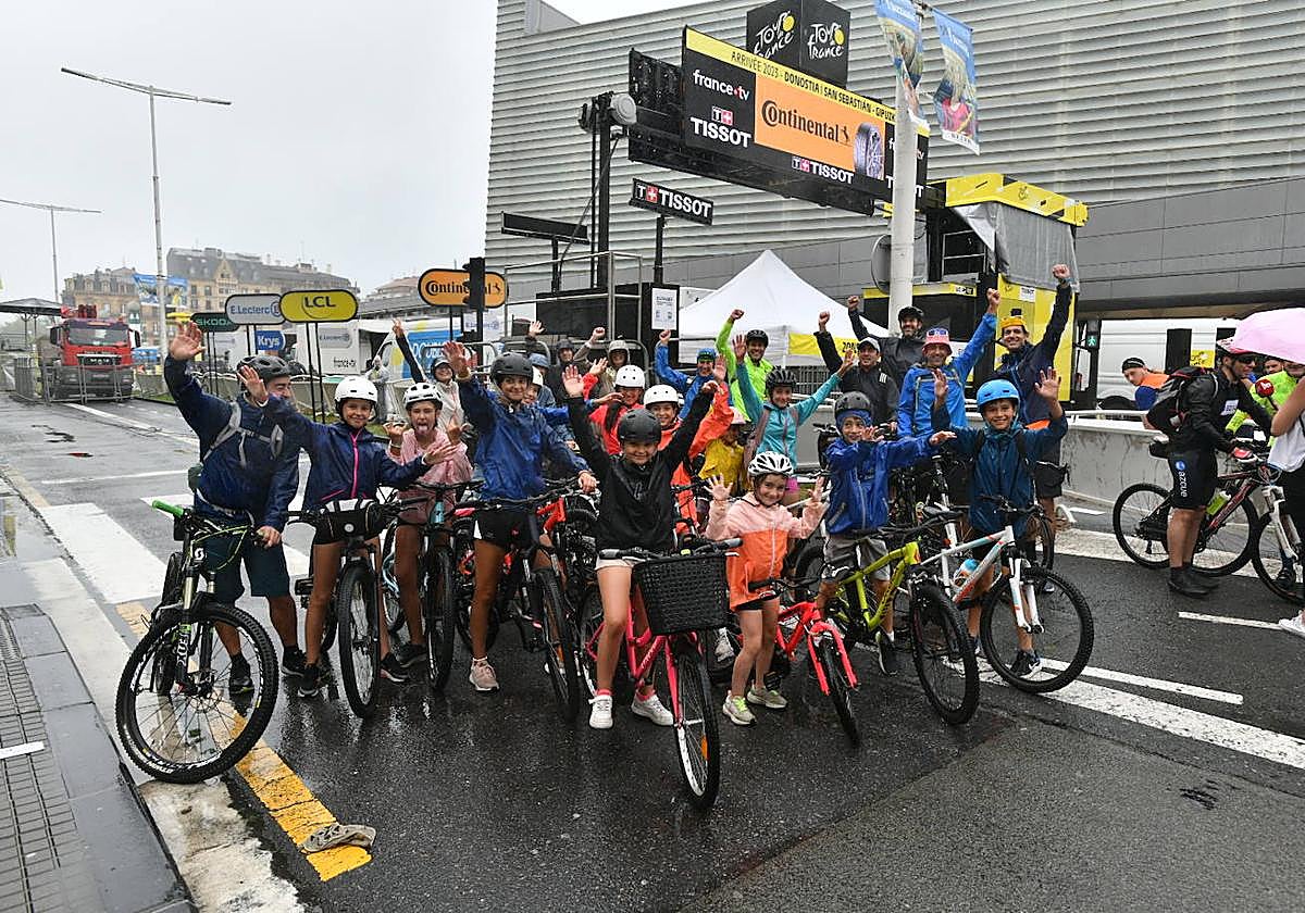 Un grupo de familias con sus bicis posan en la línea de meta del Tour en Donostia.
