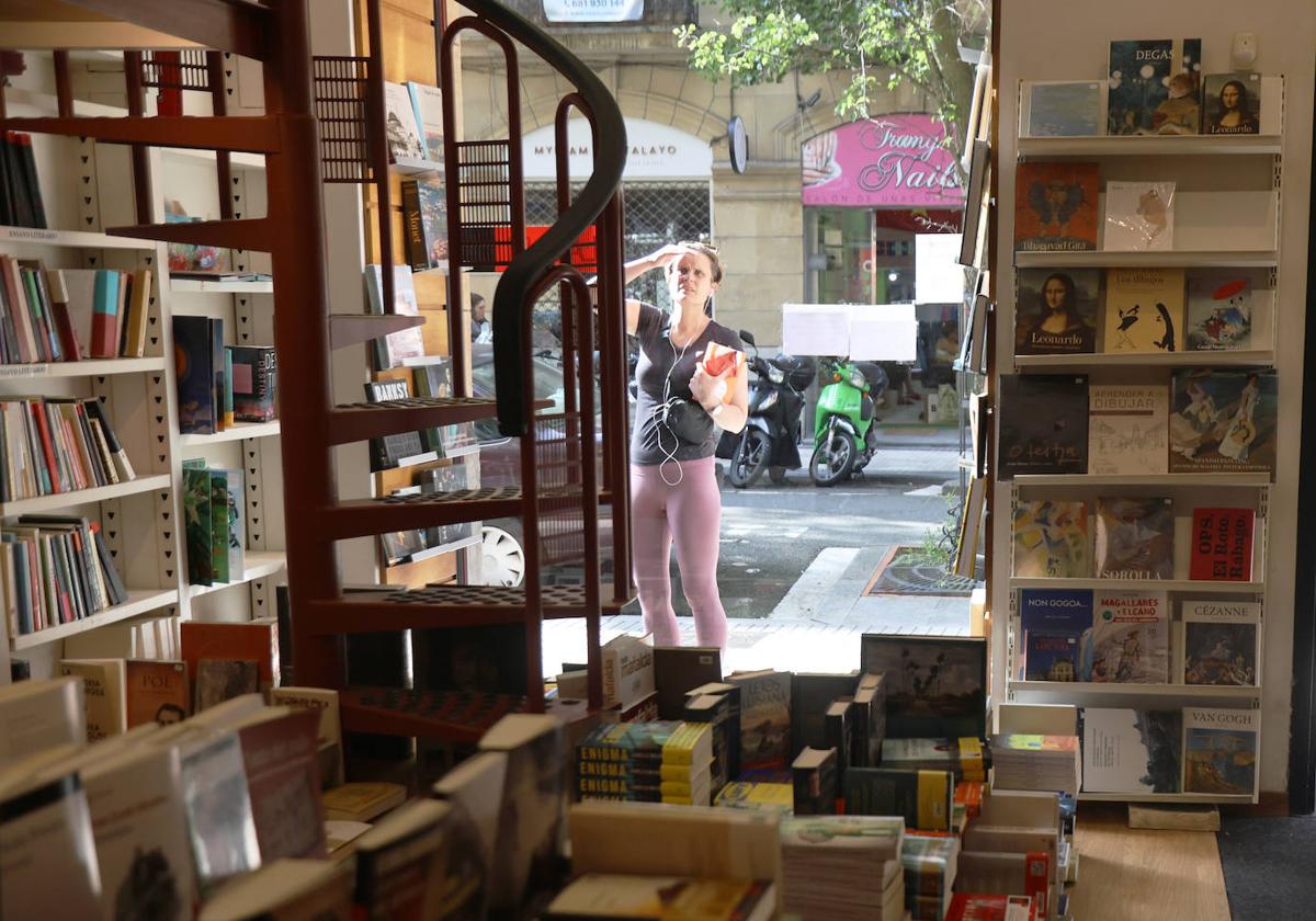 Una paseante curiosea el escaparate de la histórica librería en la calle Urdaneta, ayer por la tarde.