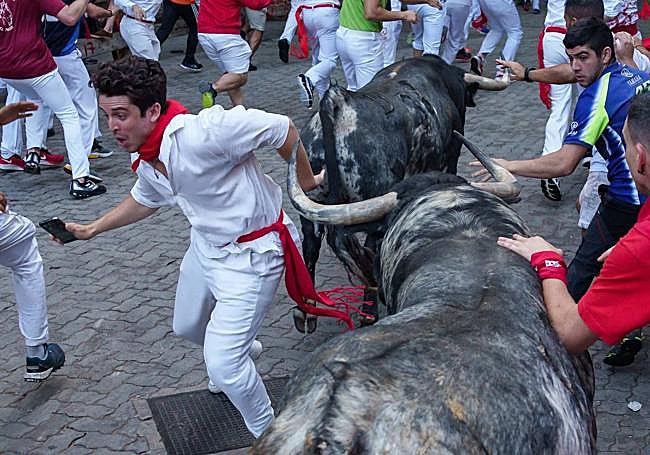 El joven con el móvil en la mano en el momento en el que se zafa del toro.