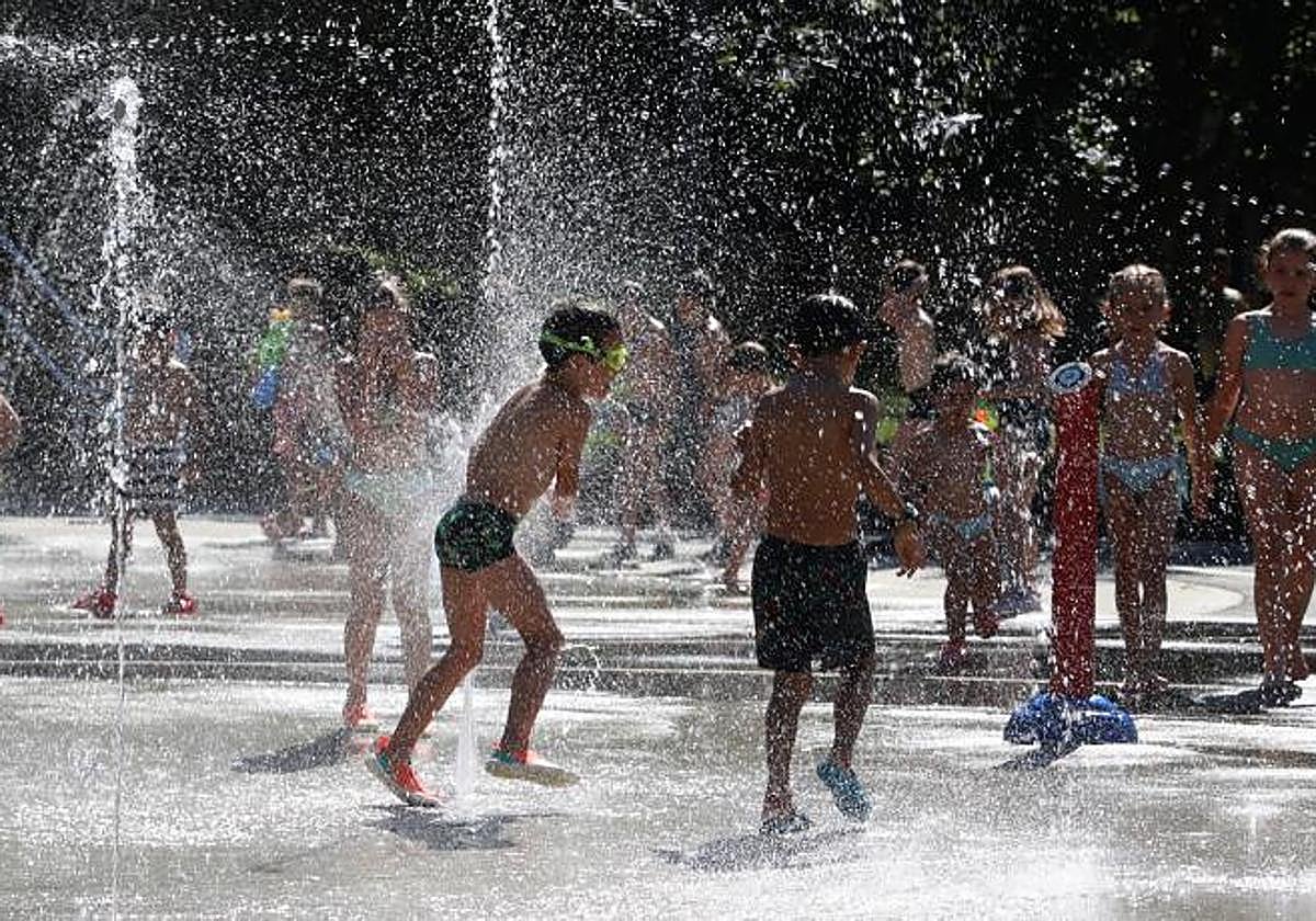 Un grupo de niños se refresca con los chorros de agua en Beasain