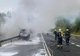La furgoneta convertida en una bola de fuego en Azkarate mientras los bomberos tratan de apagar las llamas.