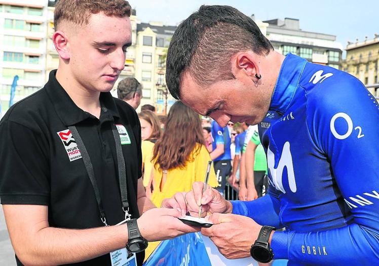 Imagen principal - Gorka Izagirre firma un autógrafo a un joven aficionado. Los seguidores no dejaron de pedir una firma a los ciclistas. Alaphilippe y Evenepoel posaron para la foto con la playa de La Concha de fondo. 