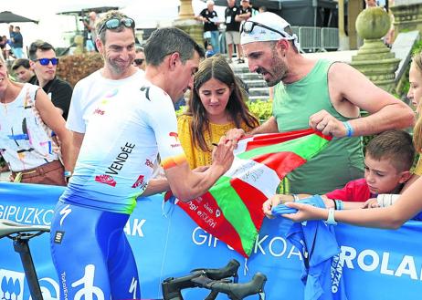 Imagen secundaria 1 - Gorka Izagirre firma un autógrafo a un joven aficionado. Los seguidores no dejaron de pedir una firma a los ciclistas. Alaphilippe y Evenepoel posaron para la foto con la playa de La Concha de fondo. 