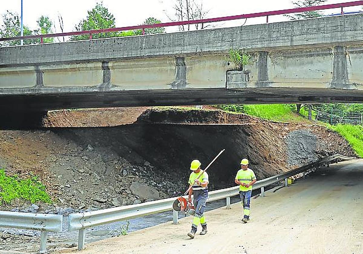 Dos obreros caminan bajo un viaducto de la N-I en Orio.