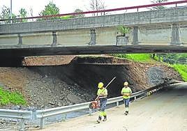 Dos obreros caminan bajo un viaducto de la N-I en Orio.