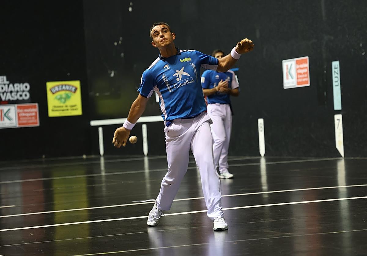 Iker Larrazabal ejecuta un saque con José Javier Zabaleta al fondo.