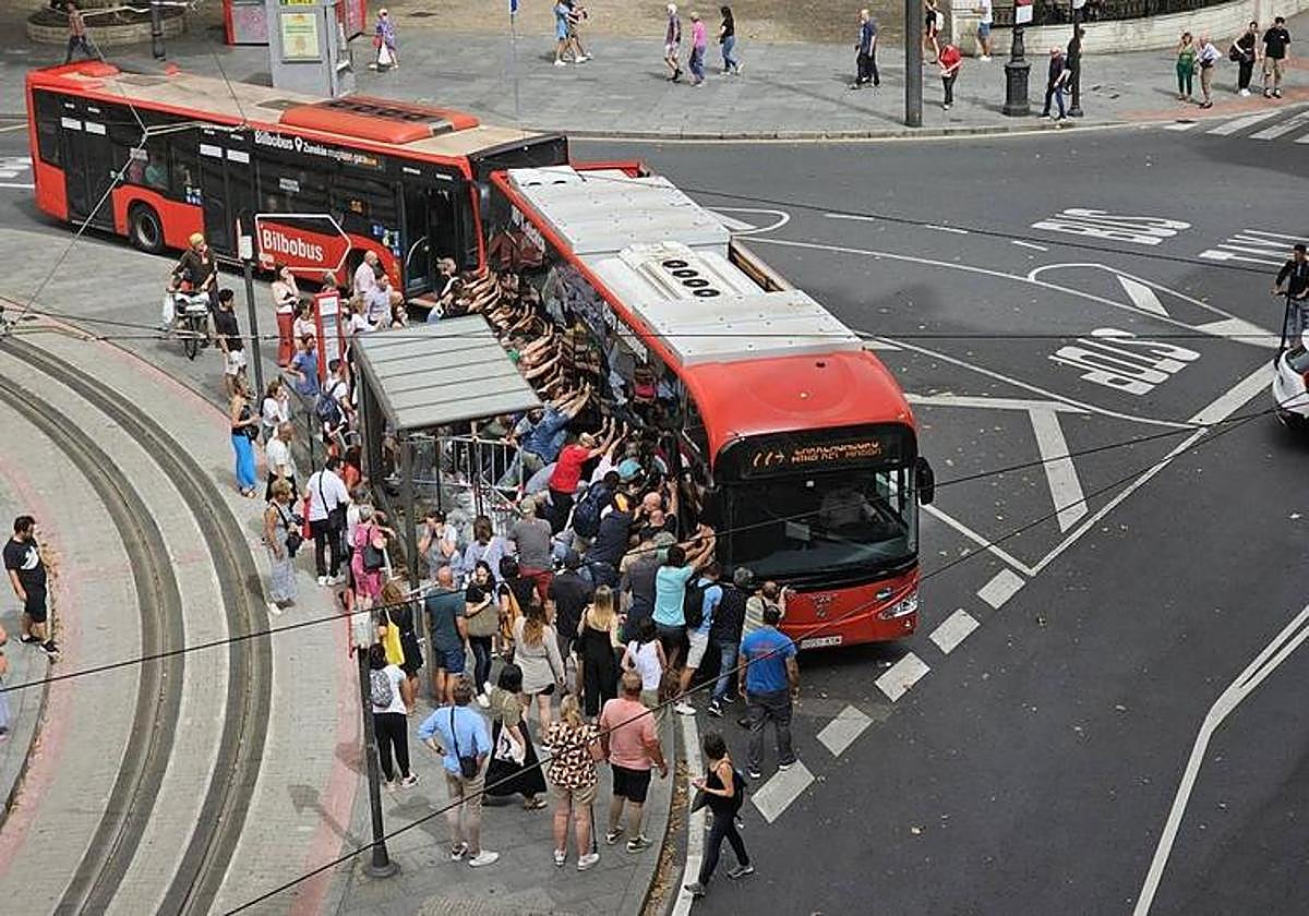 Decenas de personas empujan el autobús ante una gran expectación.