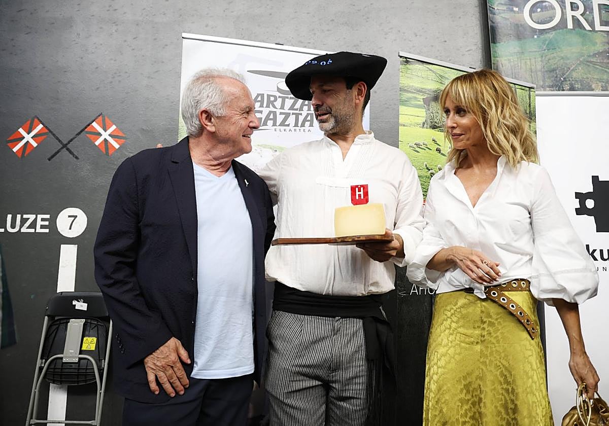 Eneko Goiburu muestra el queso ganador ante el cantante Víctor Manuel y la presentadora Emma García.
