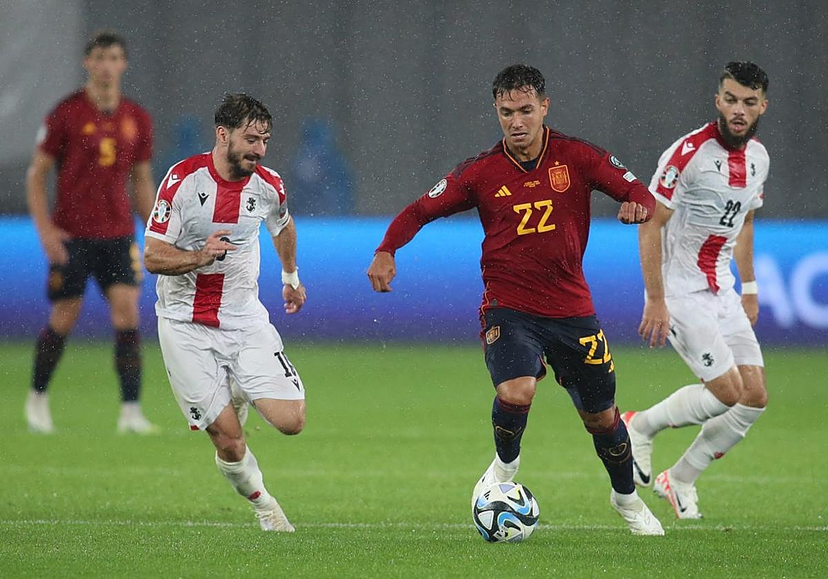 Zubimendi conduce el balón ante la oposición de dos jugadores georgianos.