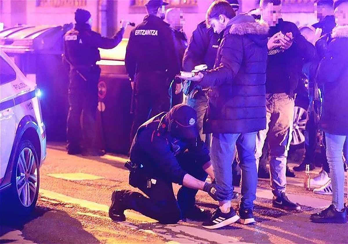 Un Ertzaina chequea a un joven.