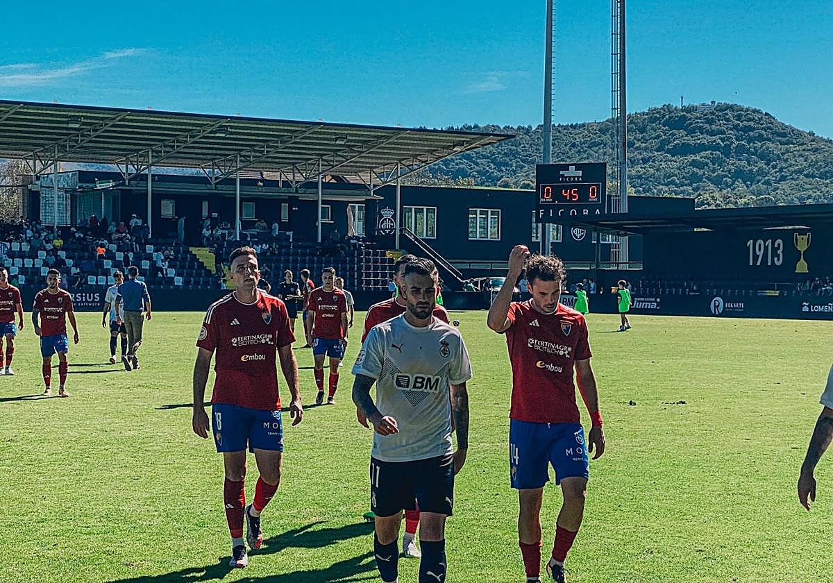 Alain Oyarzun se retira a vestuarios rodeado de jugadores del Teruel tras un primer tiempo que acabó sin goles.