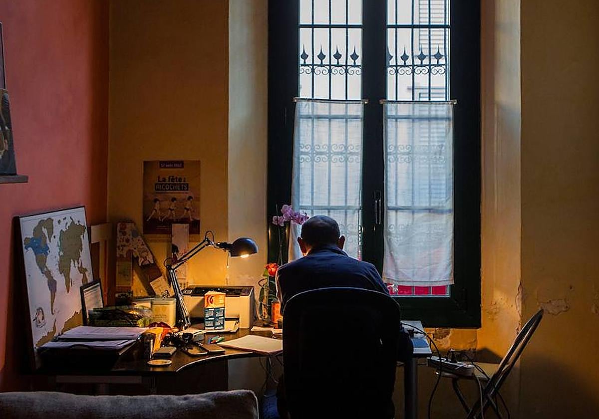 Un hombre teletrabaja en su domicilio.