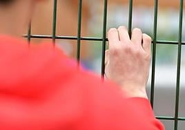 Un menor víctima de 'bullying' se asoma a un patio escolar de Gipuzkoa.