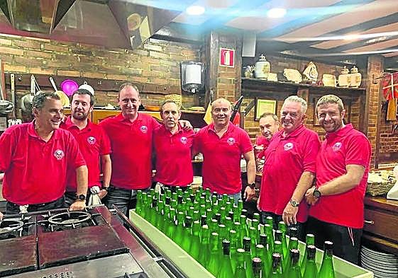 Los organizadores del concurso posan mientras refrigeran las botellas de sidra.