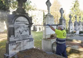 Un operario limpia la tumba de Fernando Buesa.