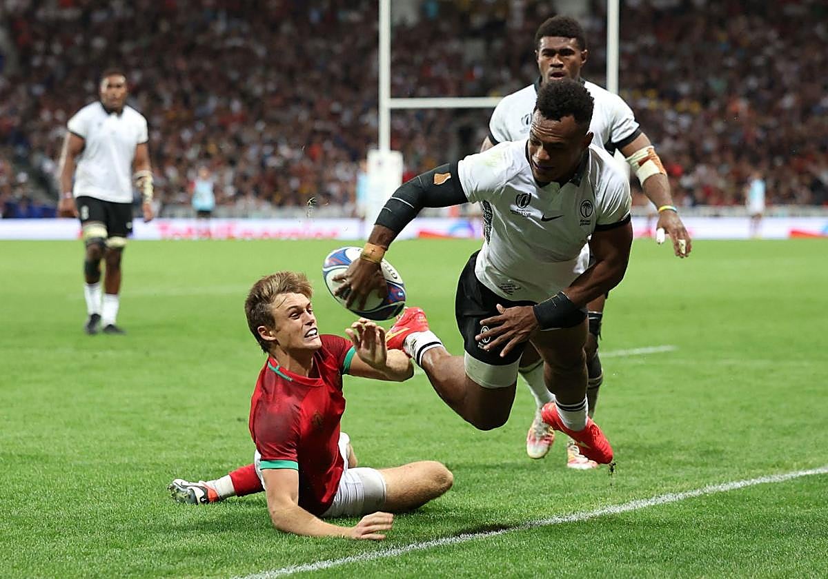 El fijiano Sireli Magale trata de evitar que el balón salga del campo ante la presión del portugués Portela.