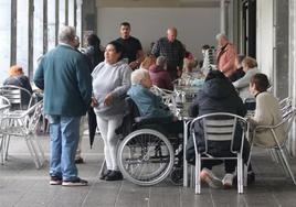 Personas mayores de Mendaro y cuidadoras conversan en la terraza de un bar del pueblo, ayer al mediodía.