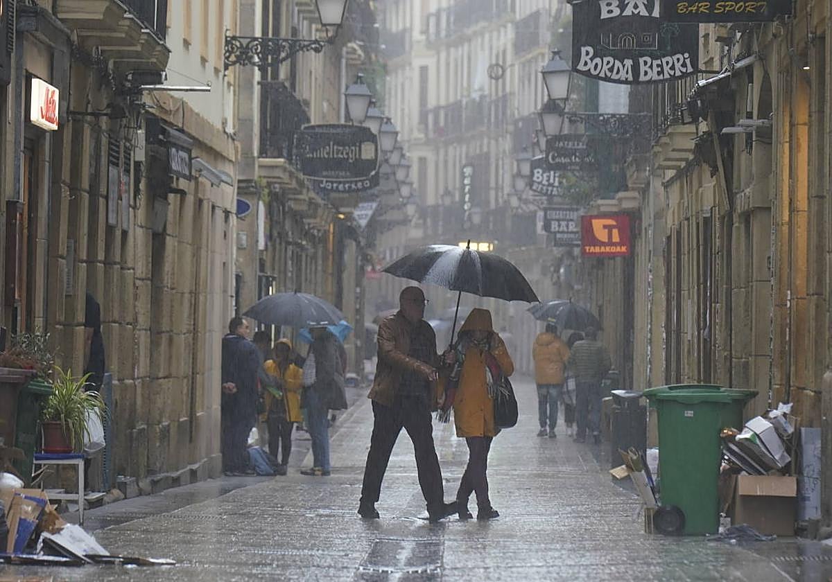 Dos personas pasean este sábado lluvisoso por la Parte Vieja.