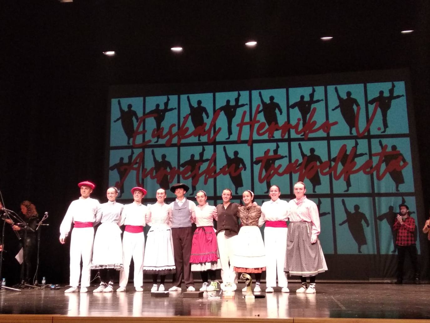 Mikel Esnaola dantzari lezoarra, erdian irabazlearen txapelarekin, gainontzeko partaideekin.