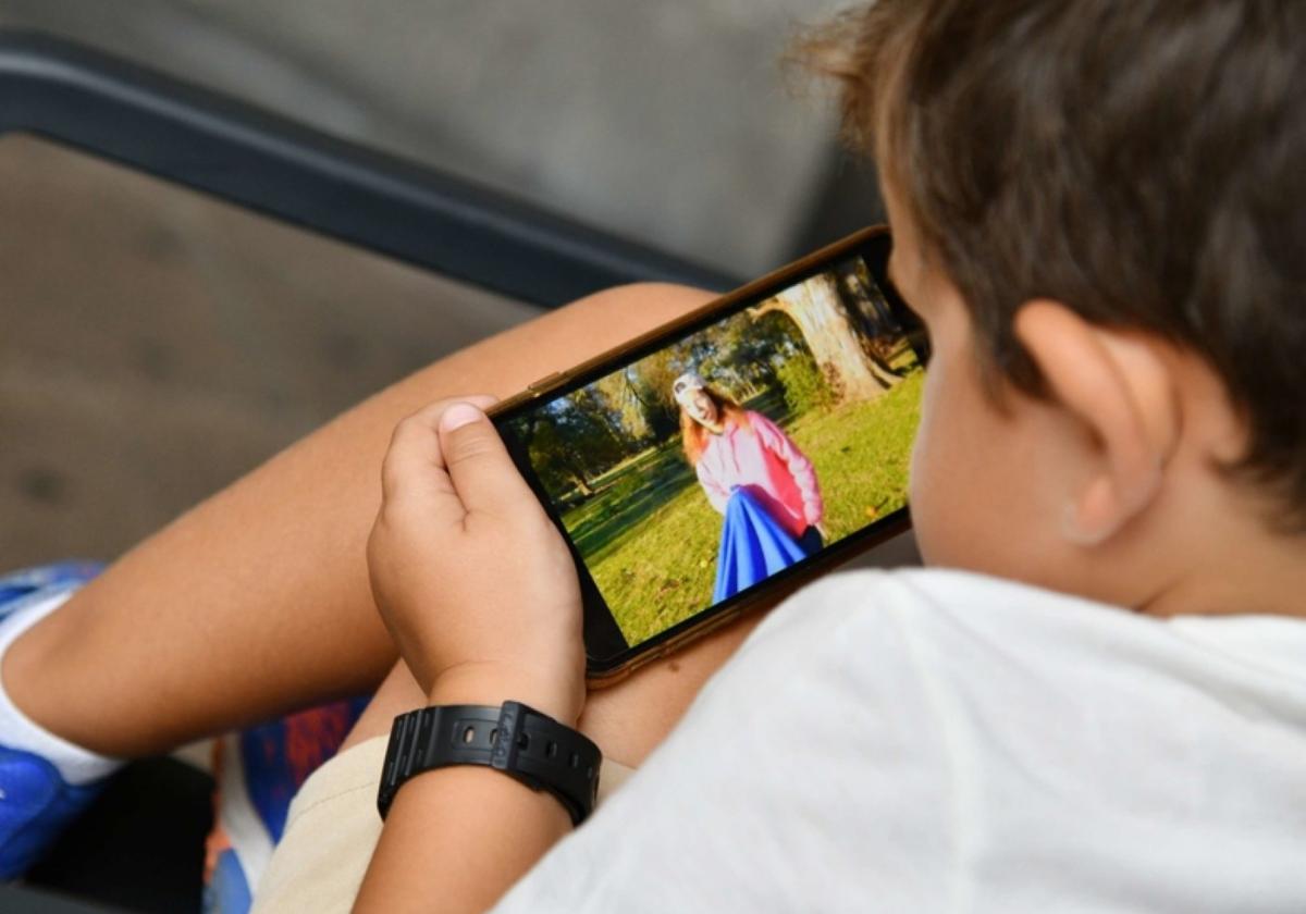 Un niño pequeño con un teléfono móvil.