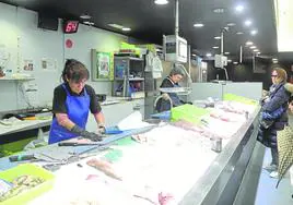 Mertxe Fernández limpia un gallo en la pescadería Nati, situada en el mercado San Martín, en Donostia.