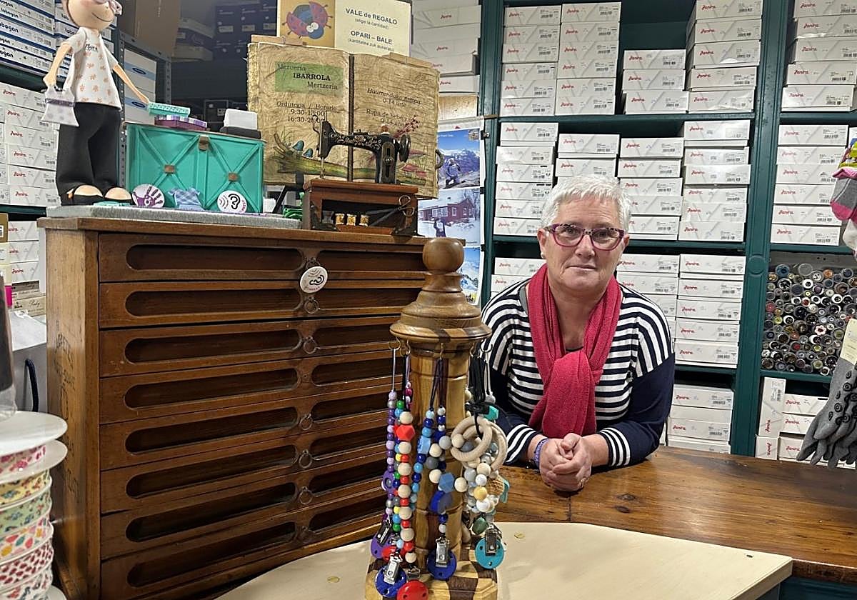 Maite Ibarrola en su tienda de Doneztebe, junto a una antigua alacena guarda carretes.