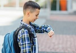 El boom de los 'smartwatch'. Un escolar de unos 8 años consulta su reloj inteligente poco antes de acceder al colegio.