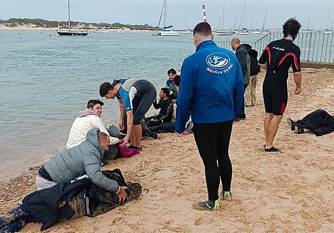 Inmigrantes rescatados en Cádiz el pasado miércoles, con Telmo Trenado agachado con uno de elos.