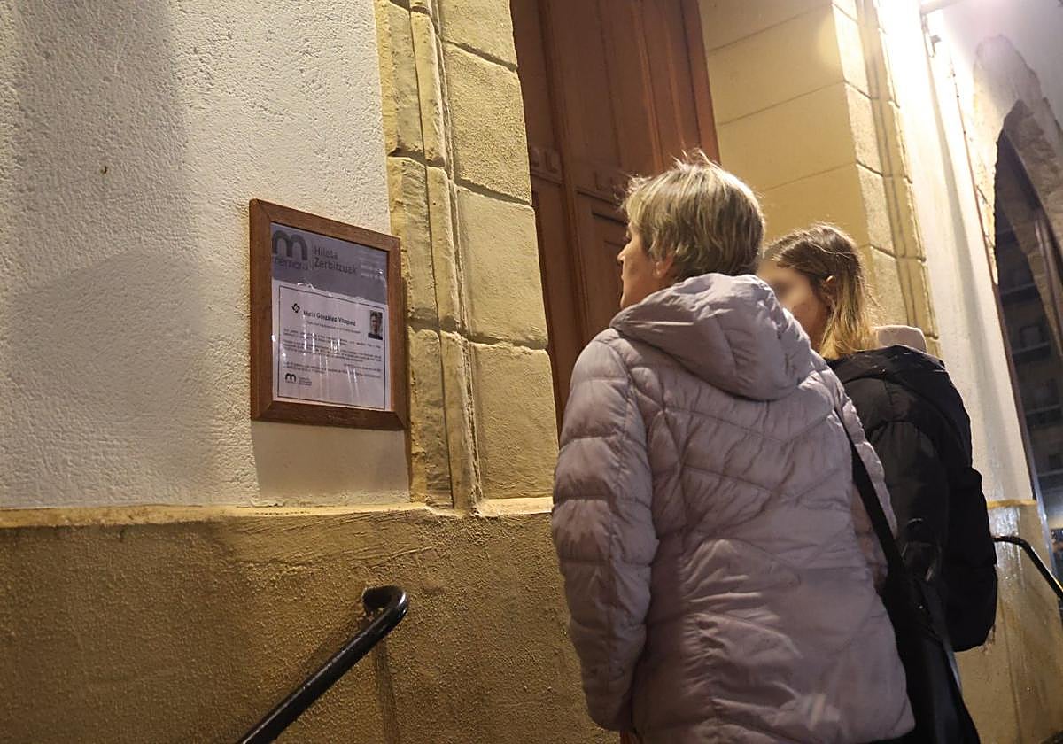 Unas vecinas miran la esquela de Iñaki G.V., uno de los dos jóvenes fallecidos, en la parroquia San Fermín de Pasai Antxo.
