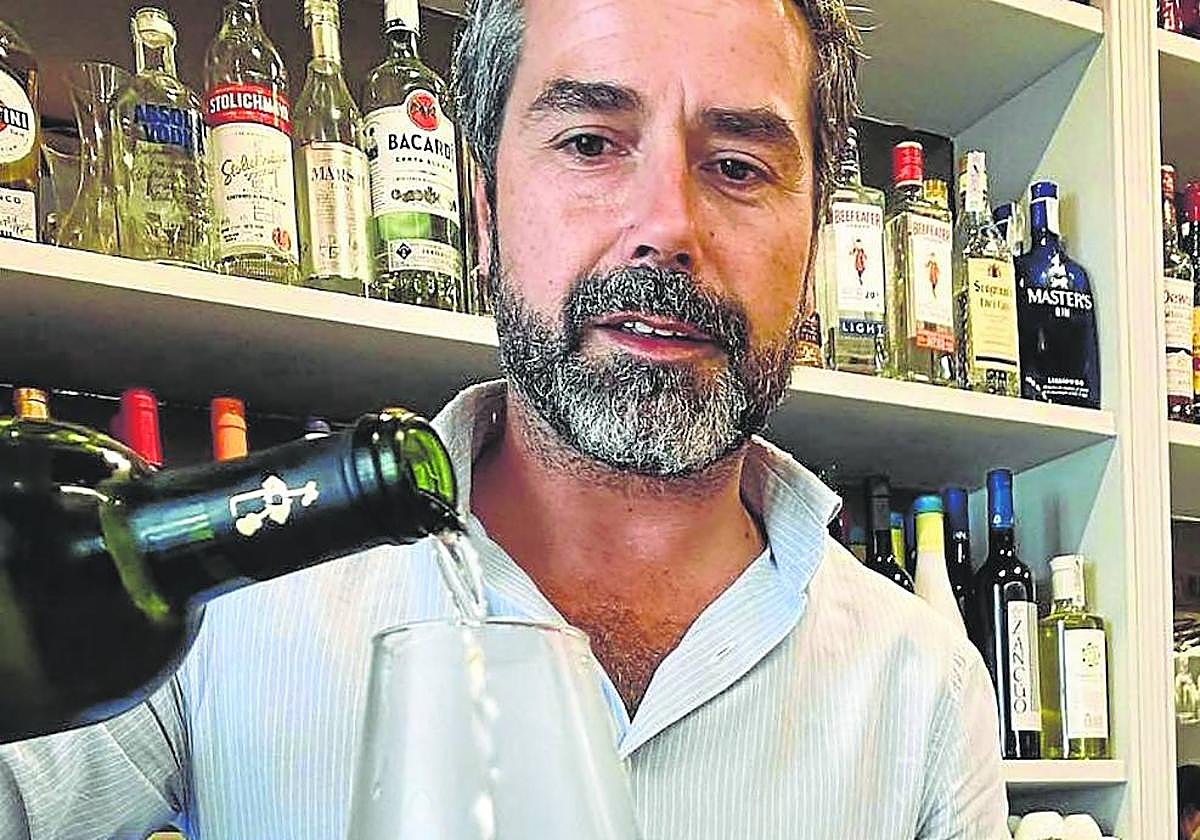Juan Palomo sirve una copa de vino en su restaurante sevillano.