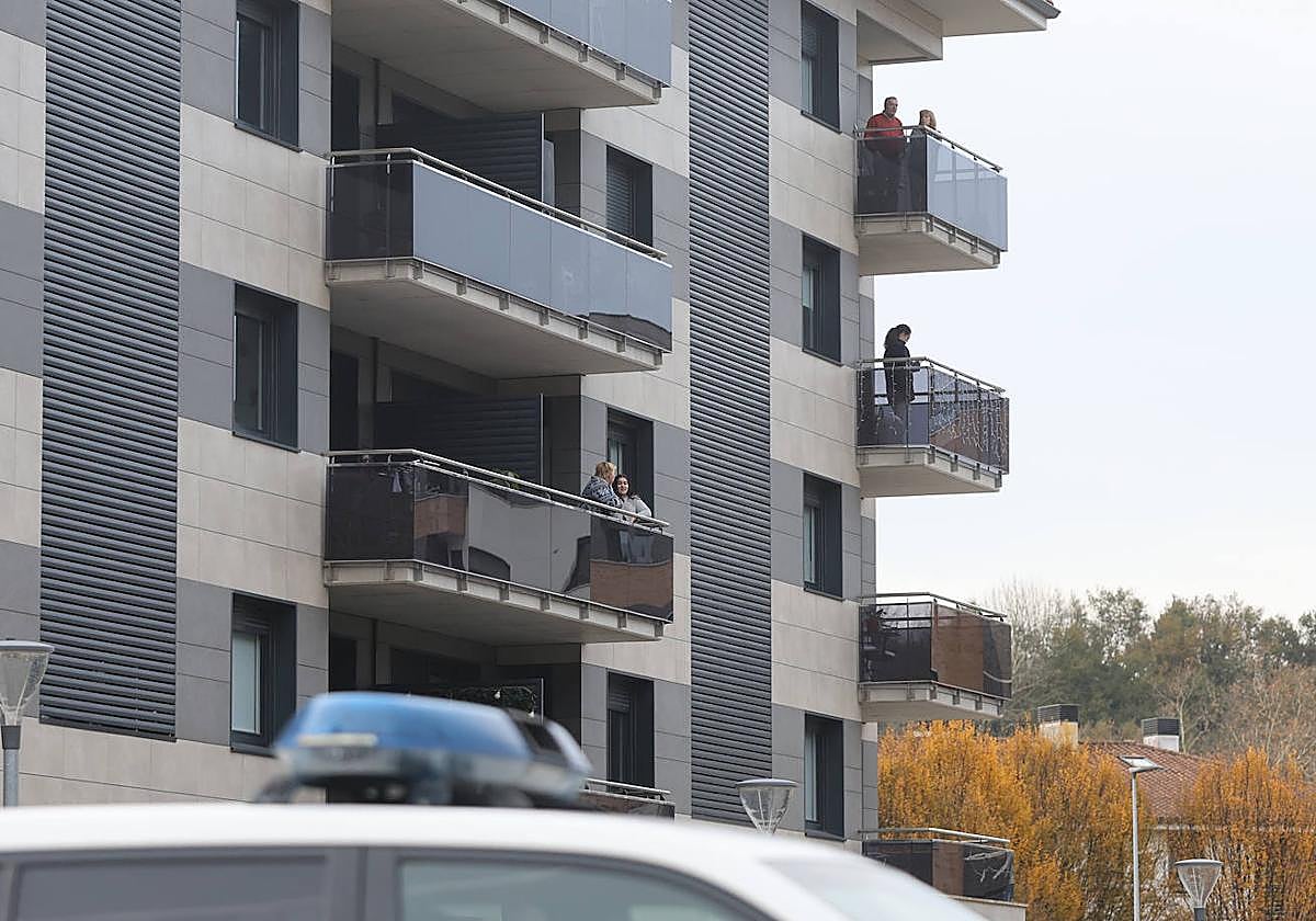 Vecinos del bloque en el que ha muerto el menor de dos años se asoman a los balcones.