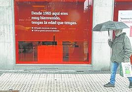 Un hombre pasea delante de una entidad bancaria en San Sebastián.
