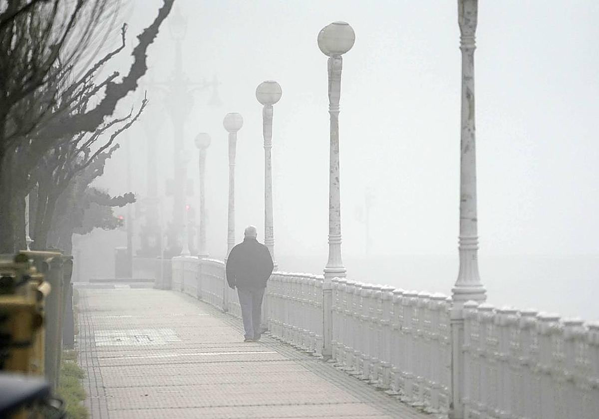 Una persona camina entre la niebla en San Sebastián.