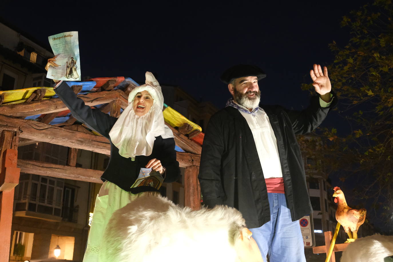 Mari Domingi y Olentzero saludan durante el desfile por las calles de Donostia.