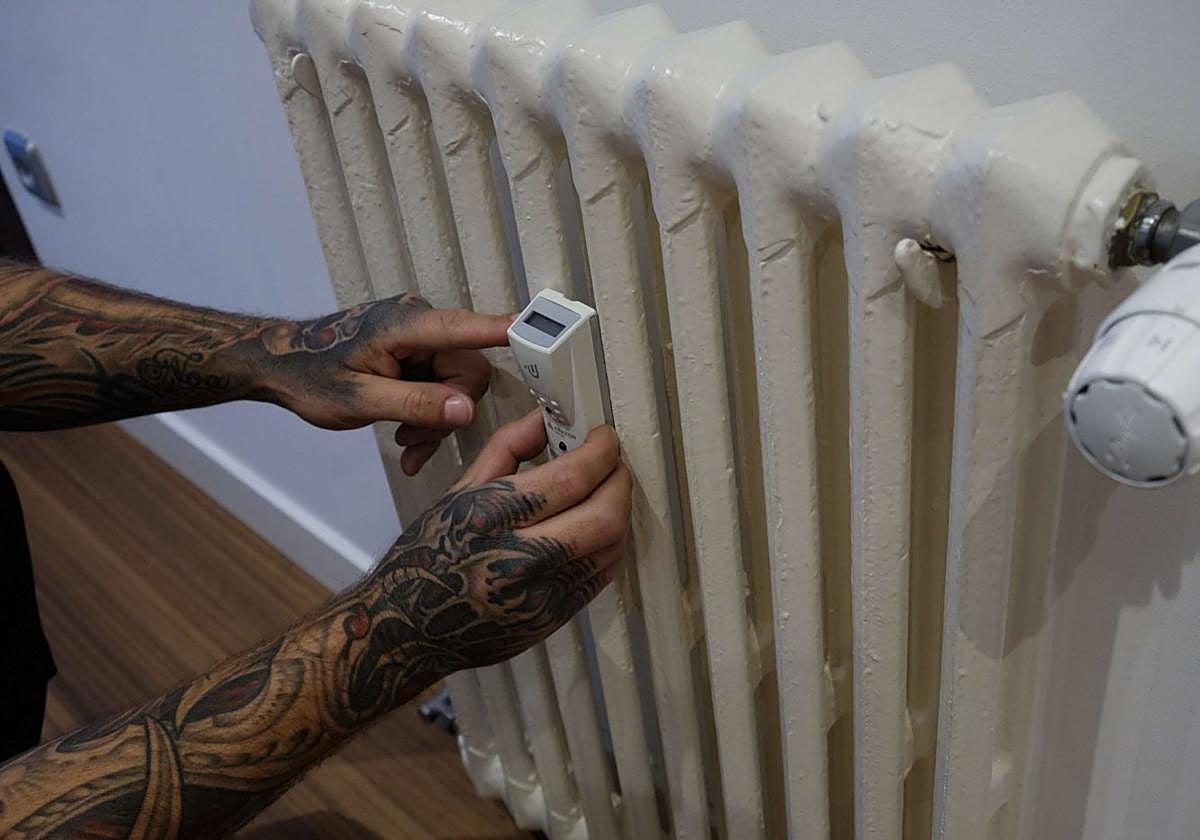 Un instalador coloca un contador individual en una vivienda con calefacción central.