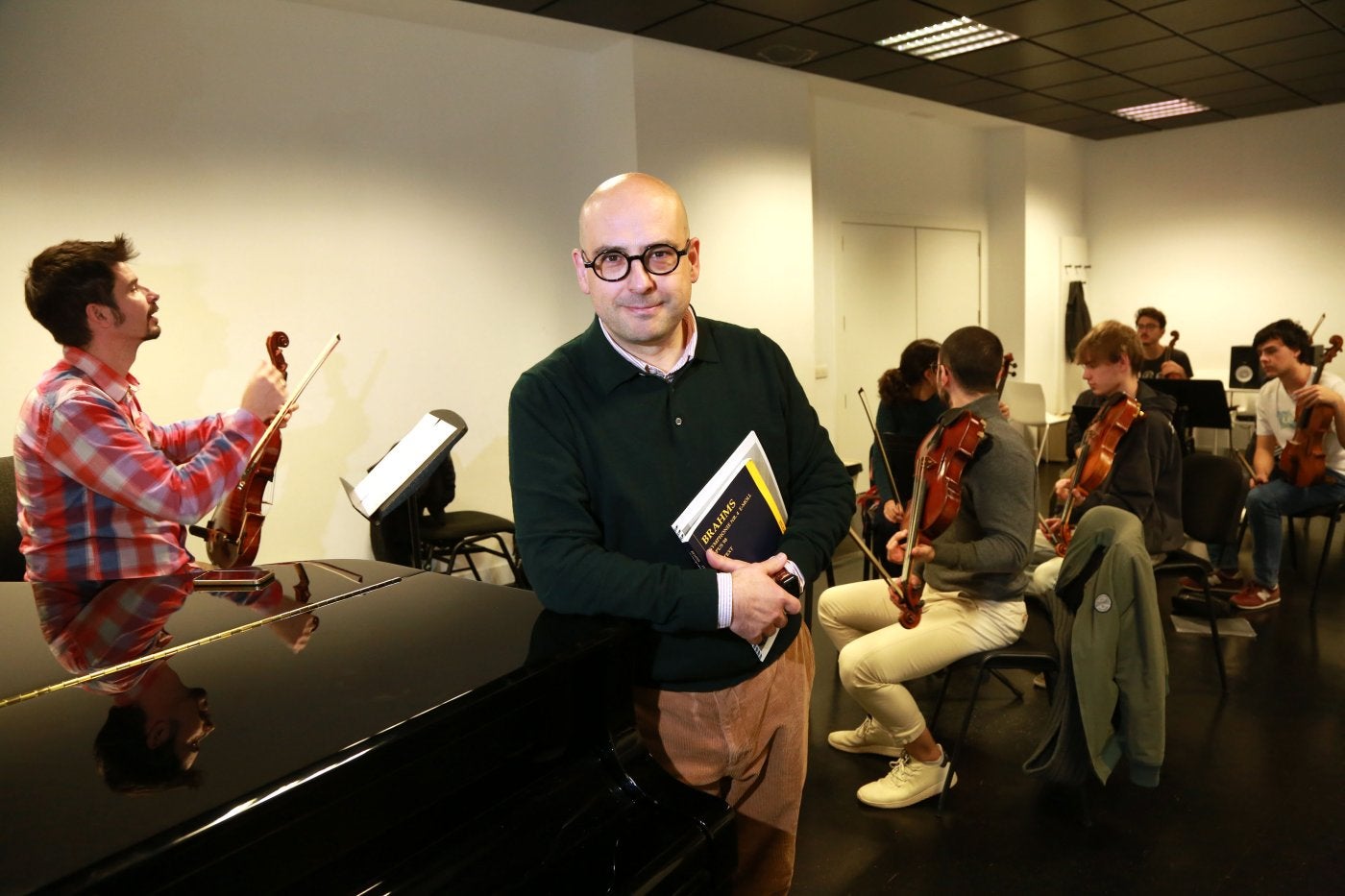 El director arrasatearra Unai Urrecho posa en una de las salas de Musikene junto a los violinistas de la Joven Orquesta de Euskadi, que durante estos días preparan el programa que ofrecerán en la gira que les llevará a Tolosa, Donostia, Vitoria y Bilbao.